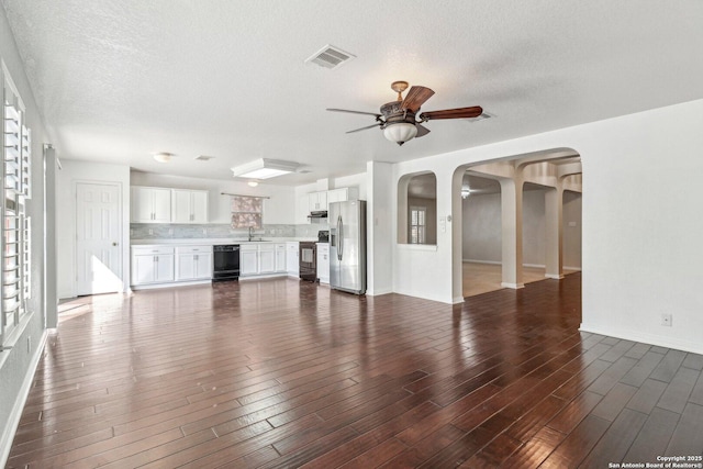 unfurnished living room featuring dark wood-type flooring, sink, a textured ceiling, and ceiling fan