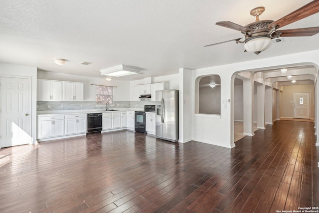 unfurnished living room featuring ceiling fan, dark hardwood / wood-style floors, sink, and a textured ceiling