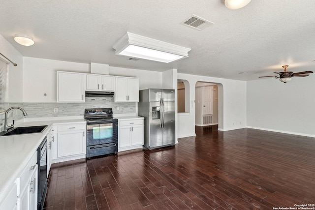 kitchen with sink, dark wood-type flooring, tasteful backsplash, black appliances, and white cabinets