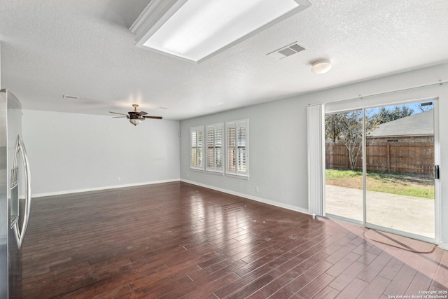 unfurnished living room with ceiling fan, plenty of natural light, a textured ceiling, and dark hardwood / wood-style flooring