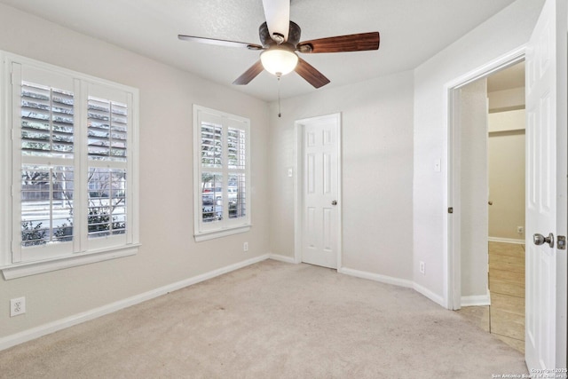 unfurnished bedroom featuring light colored carpet and ceiling fan