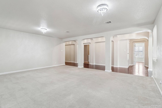 unfurnished room featuring a textured ceiling and carpet