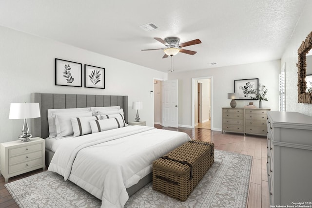 bedroom featuring ceiling fan, light hardwood / wood-style flooring, and a textured ceiling