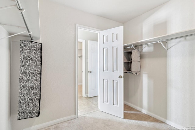 walk in closet with light colored carpet