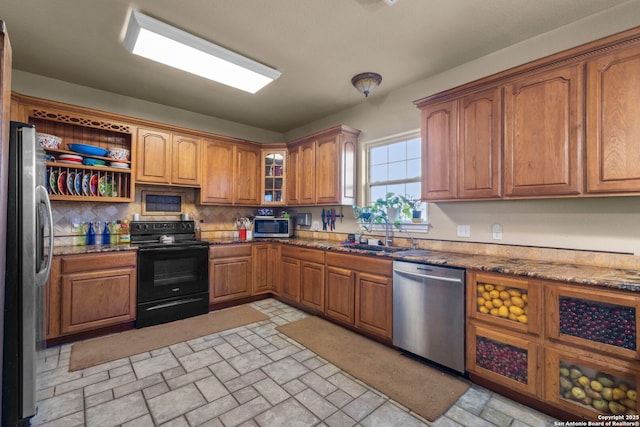 kitchen with tasteful backsplash, sink, stainless steel appliances, and dark stone counters