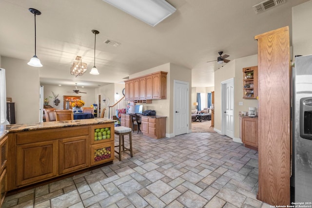 kitchen with hanging light fixtures, a breakfast bar area, and ceiling fan