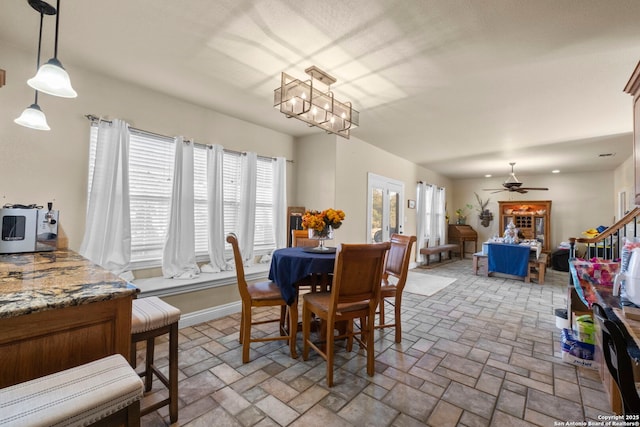 dining area with ceiling fan with notable chandelier