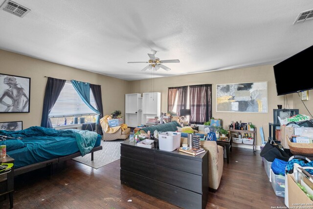 bedroom featuring dark hardwood / wood-style flooring, a textured ceiling, and ceiling fan