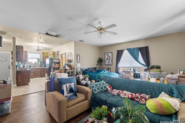 living room featuring ceiling fan with notable chandelier, a healthy amount of sunlight, and hardwood / wood-style floors