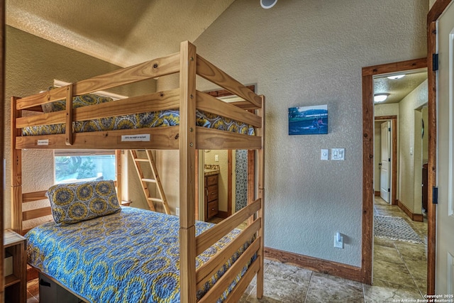 bedroom featuring lofted ceiling and a textured ceiling