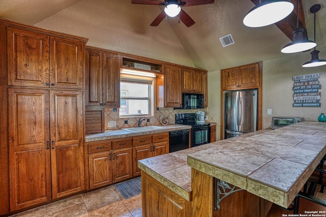 kitchen featuring sink, backsplash, black appliances, a kitchen bar, and vaulted ceiling