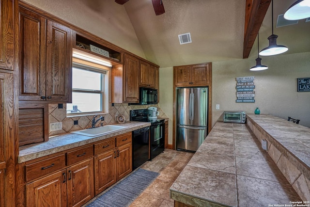 kitchen with decorative light fixtures, tasteful backsplash, sink, tile counters, and black appliances