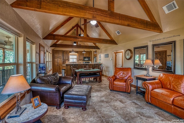 living room with ceiling fan, beam ceiling, and high vaulted ceiling