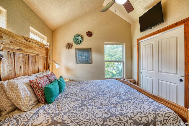 bedroom featuring vaulted ceiling, a textured ceiling, ceiling fan, and a closet