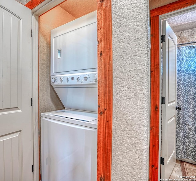 washroom featuring stacked washer and clothes dryer