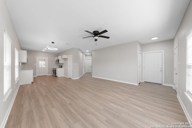 unfurnished living room with ceiling fan and light hardwood / wood-style flooring