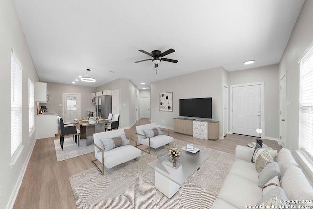 living room with ceiling fan, a healthy amount of sunlight, and light hardwood / wood-style floors