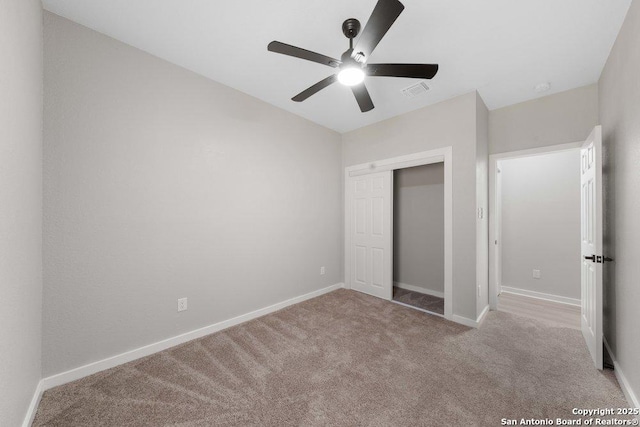 unfurnished bedroom featuring light carpet, ceiling fan, and a closet