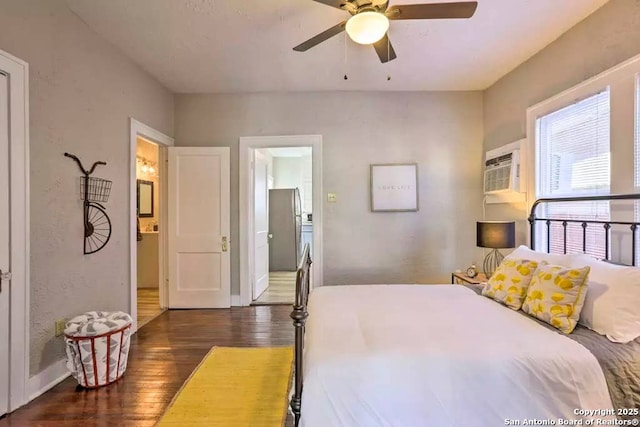 bedroom with ceiling fan, a wall mounted air conditioner, dark hardwood / wood-style floors, and ensuite bath