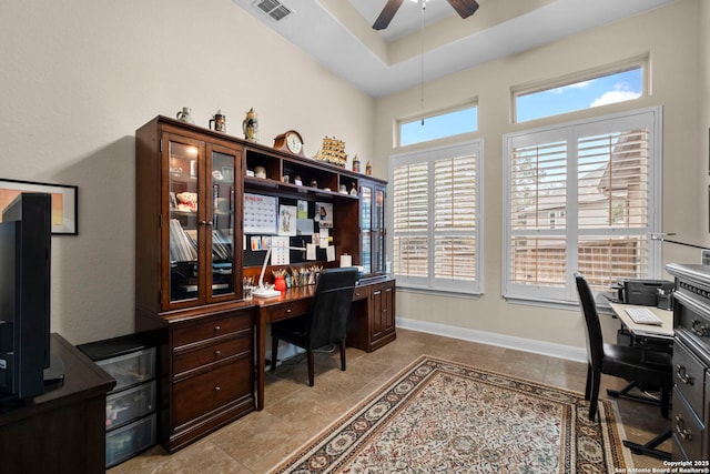 tiled office with ceiling fan and a raised ceiling