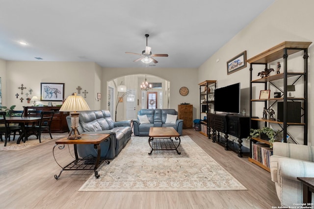 living room with ceiling fan with notable chandelier and light wood-type flooring