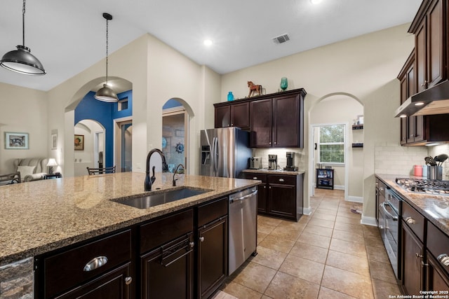 kitchen featuring pendant lighting, tasteful backsplash, sink, dark brown cabinetry, and stainless steel appliances