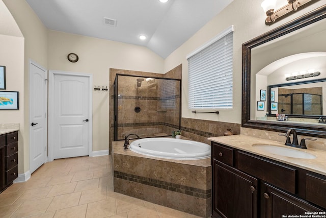 bathroom with vaulted ceiling, vanity, plus walk in shower, and tile patterned flooring