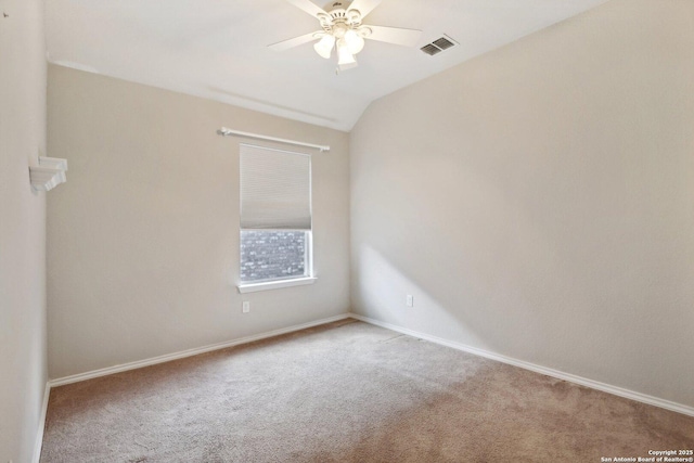 carpeted spare room featuring lofted ceiling and ceiling fan