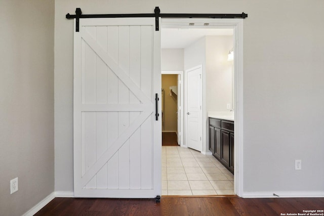 interior space with a barn door and light tile patterned floors