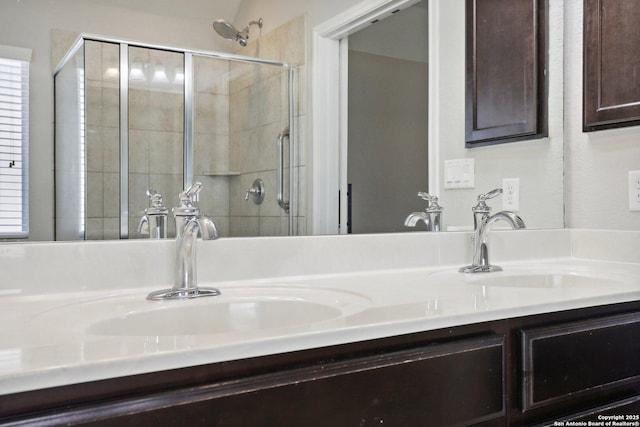 bathroom with a shower with door and vanity