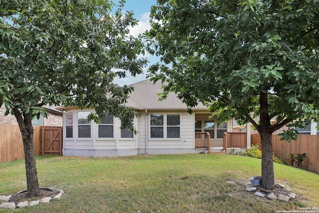 rear view of house featuring a deck and a lawn