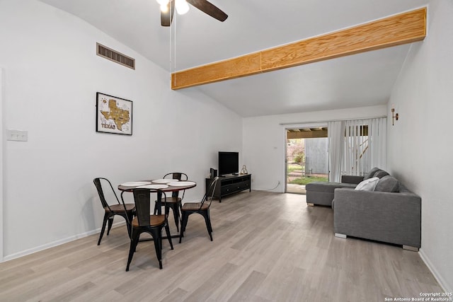 dining space featuring ceiling fan, vaulted ceiling with beams, and light hardwood / wood-style floors