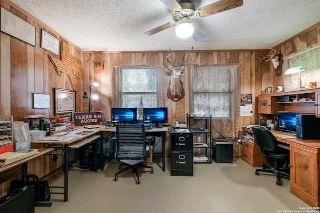 office with a textured ceiling, ceiling fan, and wood walls