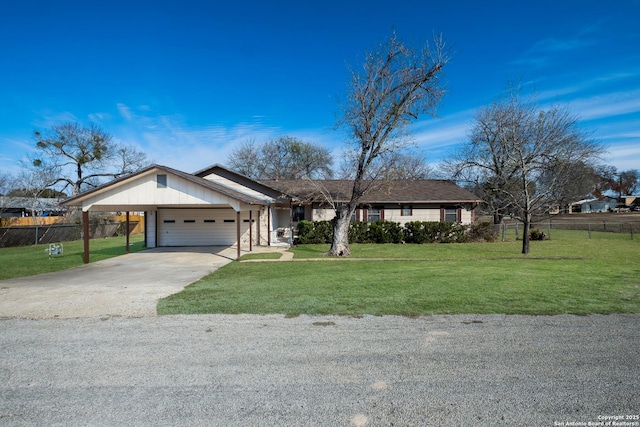 ranch-style house featuring a garage, a front lawn, and a carport