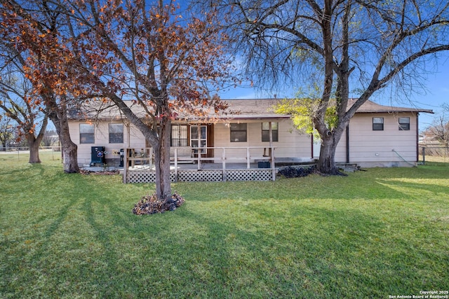 rear view of property featuring a wooden deck and a yard