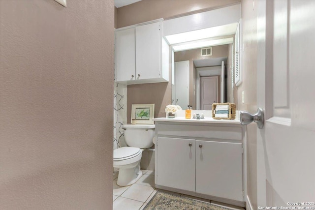 bathroom featuring vanity, tile patterned floors, and toilet