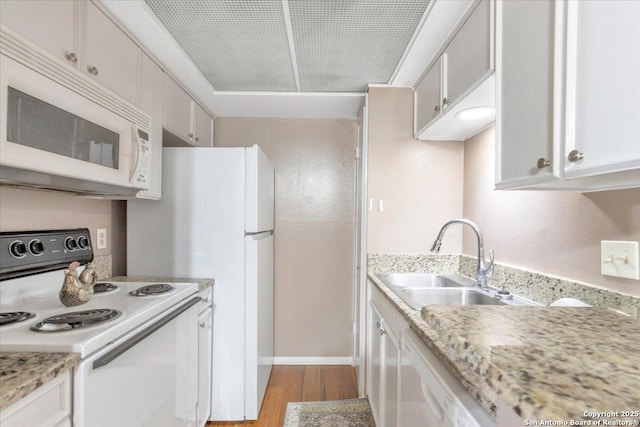 kitchen featuring sink, light stone counters, light hardwood / wood-style flooring, white appliances, and white cabinets