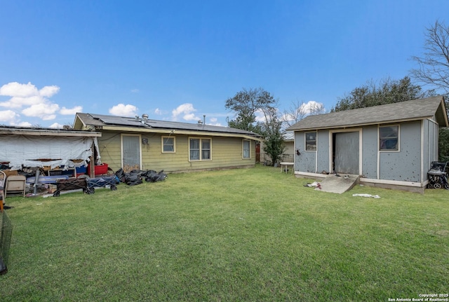 back of house with a lawn and solar panels