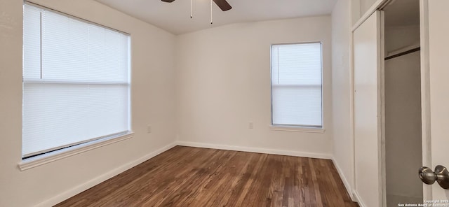 unfurnished bedroom featuring ceiling fan, dark hardwood / wood-style flooring, and a closet