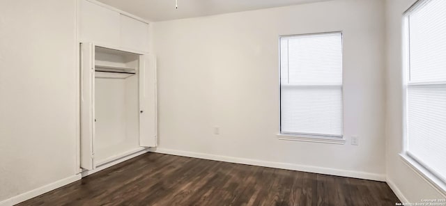 unfurnished bedroom featuring dark wood-type flooring and a closet