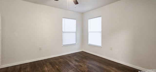 spare room with dark hardwood / wood-style floors, a wealth of natural light, and ceiling fan