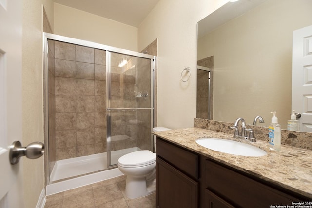 bathroom featuring vanity, toilet, tile patterned flooring, and a shower with door