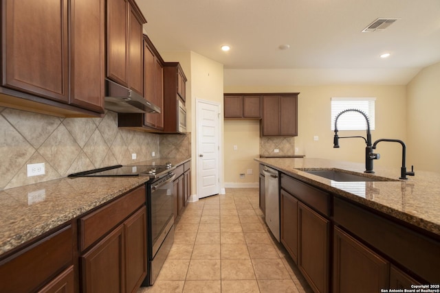 kitchen featuring appliances with stainless steel finishes, sink, decorative backsplash, light tile patterned floors, and light stone countertops