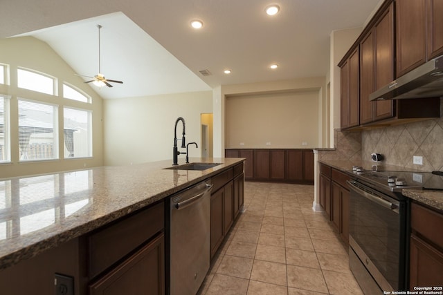 kitchen with lofted ceiling, sink, stainless steel appliances, light stone countertops, and backsplash