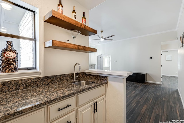 kitchen featuring sink, dark hardwood / wood-style flooring, ceiling fan, dark stone counters, and cream cabinets