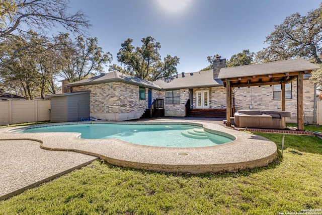 view of pool with a hot tub and a lawn