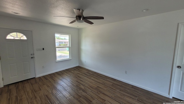 foyer with dark wood-type flooring, ceiling fan, a textured ceiling, and a wealth of natural light