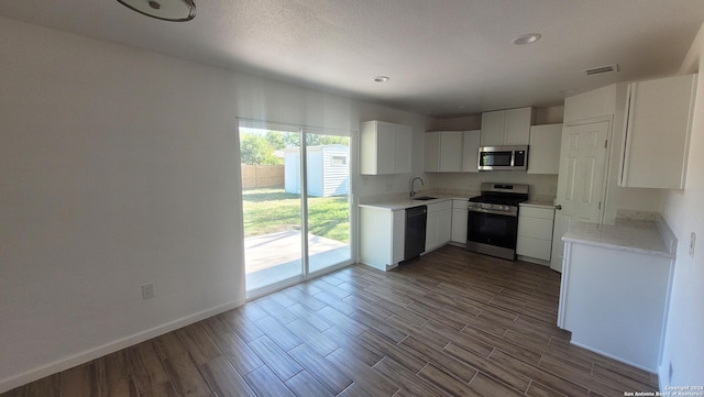 kitchen with stainless steel appliances, sink, and white cabinets