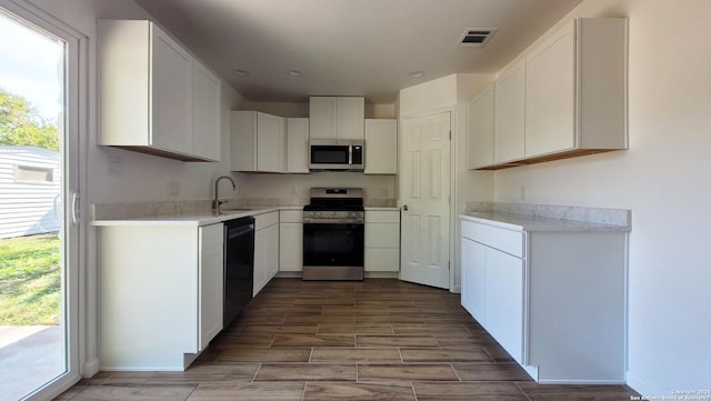 kitchen with sink, white cabinets, and appliances with stainless steel finishes