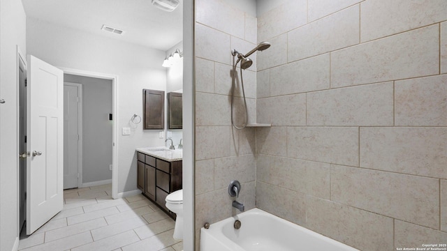 full bathroom with tiled shower / bath combo, vanity, tile patterned floors, and toilet